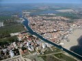 Lido degli Estensi jest włoską miejscowością położoną na brzegu Morza Adriatyckiego. Należy ona do Lidi di Comacchio, czyli siedmiu plaż, miejsc niezwykle atrakcyjnych turystycznie, wchodzących w skład, Parku Regionalnego Delty Padu (Il Parco regionale del Delta del Po dell‘Emilia-Romagna).

	
Historia

	
Sama nazwa tłumaczy pochodzenie miejscowości. Lido oznacza po włosku plaża, zaś d‘Este to nazwa książęcego rodu, do którego ziemia ta należała. Ród d‘Este jest jednym z najstarszych rodów Lombardii. Podobno mieli wywodzić się ze szlachty, która służyła jeszcze Karolowi Wielkiemu, władcy Franków. Ród władał w miastach Ferarra i Modena (tak, właśnie w tych, z których pochodzą najsłynniejsze sportowe auta na świecie: Ferrari, Lamborghini, Maserati, De Tomaso, Pagani). Kiedyś stał tu nawet pałac książęcy (Casette di Magnavacca), niestety już nie istnieje.

	
Atrakcje

	
Miejscowość zapewnia turystom wiele atrakcji. Nie ma miesiąca w sezonie turystycznym, w trakcie którego nie byłoby festynu, hucznego święta czy wydarzenia sportowego. Od miasta do plaży ciągnie się promenada dostosowana zarówno dla pieszych jak i dla rowerzystów. Plaża natomiast jest dostosowana także dla dzieci i ich rodziców, którzy boją się zobaczyć swoje pociechy w nieprzewidywalnym morzu - na południu Lido d‘Estensi znajduje się słodkowodny basen z mamucią zjeżdżalnią, która z pewnością będzie nie lada atrakcją dla niejednego żądnego wrażeń malucha.

Zwolennicy ruchu na świeżym powietrzu nie powinni być zawiedzeni. W ośrodku sportowym Medusa znajdują się aż trzy korty tenisowe, boisko do piłki nożnej i siatkówki. Także na plaży można wziąć udział w turnieju siatkówki plażowej.

Już 18 lipca odbędzie się tutaj wielka impreza - Salsa na ulicy (Salsa Festival Street). Promenada zmieni się wówczas w wielki korowód taneczny. Każdy, kto będzie wówczas w okolicach Lido degli Estensi, ma szansę poznać tajemnice salsy zdradzane przez zawodowych tancerzy z całego świata. W tym roku gościem imprezy będzie Natalia Titova - zwyciężczyni włoskiej edycji Tańca z Gwiazdami (emitowanego na kanale RAI 1).


Comacchio


Zaledwie 5 km od Lido degli Estensi leży miasteczko Comacchio. Początkowo było zamieszkiwane przez ludy etruskie i galijskie, jednak szybko zostało włączone do granic Starożytnego Rzymu. Gdy Imperium padło, miasto całkiem dobrze rozwijało się pod rządami barbarzyńskich Gotów i Longobardów, stając się nawet siedzibą księstwa. W czasach Frankijskiej inwazji na północy Włoch w 756 r. n. e., Pepin Mały pokonał Longobardzkiego króla Aistulfa i odebrał mu m. in. miasto Comacchio, które następnie przekazał papieżowi Stefanowi II. Stworzył wówczas Państwo Kościelne (Patrimonium Sancti Petri). W 854 r. zostało splądrowane przez Wenecjan i zniszczone 946 r. Stolica Apostolska odbiła miasto i przekazała arcybiskupowi Raveny. W XIII wieku Cesarz Niemiecki Rudolf I oficjalnie oddał Comacchio w ręce Obizzo IV d‘Este. W ten sposób przekazał je rodzinie Estensi. Niestety w 1508 r. miasto znów zajęli Wenecjanie. W 1597 r. stało się lennem papieża Klemensa VIII, by rok później znów stać się częścią Państwa Kościelnego. Dopiero w 1866 gdy ostatecznie stało się częścią zjednoczonych Włoch.
	
Tak bogate dzieje sprawiły, że zwiedzając miasto widzimy świadectwa wielowiekowej historii. Wizytówką miasta jest zachwycający swoją konstrukcją i hipnotyzującą symetrią XVII - sto wieczny most Pallota - koniecznie trzeba go zobaczyć. Poza tym warto obejrzeć Palace Patrignani i Tura Palace (XVI w.), Sanktuarium Santa Maria (XVI w.), Kościół San Cassiano (XVII w.), Kościół Różańca (XVII w.) czy Klasztor Sant‘Agostino (XVII w).


Park Regionalny Delty Padu (Il Parco regionale del Delta del Po dell‘Emilia-Romagna)


Będąc w Lido degli Estensi warto udać się na wycieczkę po Parku Regionalnym Delty Padu. Został on założony w 1988 roku, by już w 1999 zostać wpisanym na Listę Światowego Dziedzictwa UNESCO. W trakcie wędrówki po parku powinniśmy wstąpić do Zamku Mesola w Ferrarze, Zakładu Marynowania Ryb (wykonujący swoje czynności metodami tradycyjnymi), warzelni soli, czy Pałacu św. Alberta, który jest prawdziwą gratką dla ornitologów. Dzięki kolekcji Alfredo Brandoliniego zgromadzonej w pałacu, możemy poznać gatunki ptactwa występujące w delcie Padu. Miłośnicy ornitologii po tej wstępnej lekcji mogą udać się na jedną z sześciu tras przeznaczonych specjalnie na obserwacje skrzydlatych mieszkańców delty.

	
Zakwaterowanie

	
Jeśli chodzi o miejsca noclegowe, Lido d‘Estensi zapewnia nam ich pod dostatkiem. Możemy tu wynająć zarówno pokój w pensjonacie, domek bungalow, jak i pokoje w hotelach dwu-, trzy-, a nawet czterogwiazdkowych, oraz znaleźć dogodne miejsce na campingu. Oczywiście nie warto jechać w ciemno, a rezerwacji należy dokonać przed wyjazdem. Jak to w adriatyckich nadmorskich miejscowościach bywa - jest ono wręcz oblegane przez turystów.