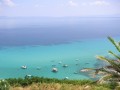 Półwysep Chalcydycki jest jednym z najpopularniejszych pod względem turystycznym regionów Grecji. Turyści przybywający z całego świata odnajdują tutaj wszystko to, co w kraju tym najlepsze. Są tu piękne, piaszczyste plaże, ciepłe, przejrzyste wody morskie idealne do kąpieli i uprawiania sportów wodnych oraz pełne słońce na bezchmurnym niebie niemal każdego dnia. Na krajobraz tej malowniczej krainy składają się ciągnące się kilometrami pola tytoniu, drzewek oliwkowych i cytrusów oraz wzgórza porośnięte sosnami i śródziemnomorską roślinnością. Wiele tutaj typowo turystycznych kurortów wypoczynkowych z dobrze rozwiniętym zapleczem gastronomicznym i bazą noclegową, jak również małych wiosek typowo greckich, w których mieszkańcy żyją spokojnym, od lat niezmienionym rytmem. Na Półwyspie Chalcydyckim odnajdziemy oczywiście i to, co od razu przychodzi nam do głowy, gdy myślimy Grecja - podobnie jak w całym kraju, także i tutaj wiele jest unikatowych zabytków będącymi pozostałościami po dawnej świetności starożytnej cywilizacji.


Położenie i klimat


Półwysep położony jest w północnej Grecji w Macedonii Środkowej nad Morzem Egejskim na wschód od Salonik. Chalkidiki posiada bardzo charakterystyczny kształt, który kojarzy się z dłonią o trzech długich placach. Owe „palce” to trzy leżące w pobliżu siebie półwyspy - Athos, Kassandra i Sithonia. Wody, które oblewają ich wybrzeża, tworzą zatoki - Kasandryjską i Ajiu Orus. Chalkidiki leży także nad Zatoką Termajską i Salonicką. Na północy półwyspu znajdują się dwa jeziora, Koronia oraz Wolfi, a środek tego regionu zajmują góry. Panuje tutaj klimat śródziemnomorski. Lata są gorące i suche - to świetny czas na wypoczynek na plaży, ale najlepszą porą na urlop w tej części Grecji są miesiące wiosenne i jesień, kiedy temperatury są jednak nieco niższe i mniej męczące.


Atrakcje turystyczne


Największą atrakcją Chalkidiki są jego trzy półwyspy. Na Kassandrze i Sithoni wzdłuż wybrzeży ciągną się kilometry pięknych, zadbanych plaż, w pobliżu których znajdują się kurorty wypoczynkowe oferujące wiele możliwości przyjemnego spędzenia czasu, także po zmroku w licznych klubach i nocnych lokalach. W dzień można opalać się, nurkować, pływać albo wypożyczyć rowery, narty wodne czy deski surfingowe. Piękna, dzika przyroda wewnątrz półwyspów i malownicze widoki zachęcają do długich spacerów. Wielu turystów decyduje się na objazdowe wycieczki wzdłuż wybrzeży dookoła zarówno Kassandry, jak i Sithoni - wyprawy te nie trwają zbyt długo, a dają możliwość zobaczenia wielu ciekawych miejsc i pięknych krajobrazów.
 
W połowie drogi między półwyspami, znajduje się usytuowany na wzgórzu Olint. Podziwiać można tam pozostałości dawnego miasta, będące unikatowym zabytkiem architektonicznym starożytnej Grecji dającym bardzo dokładne wyobrażenie o tym, jak ówcześnie budowano miasta. Kierując się na północ w głąb lądu trafimy do Poligros, gdzie znajduje się godne uwagi muzeum archeologiczne i kościół św. Mikołaja. Niedaleko można odwiedzić zamieszkiwaną w paleolicie Jaskinię Petralonę, w której podczas prac archeologicznych znaleziono szczątki wielu zwierząt, a przede wszystkim kości pierwotnego człowieka żyjącego na tych terenach ponad 700 tysięcy lat temu. Wykopaliska podziwiać można w pobliskim muzeum. Warto wybrać się do leżącej na wschodzie Stagiry - jest ona atrakcyjna ze względu na ruiny starożytnego miasta, jak również rozsławiona jako miejsce narodzin wielkiego starożytnego filozofa Arystotelesa; znajduje się tam jego współczesny pomnik.
 
Prawdziwym skarbem nie tylko Chalkidiki, ale całej Grecji, jest trzeci chalcydycki półwysep - Athos, Republika Mnichów. To autonomiczna, niedostępna jednostka administracyjna zamieszkiwana przez mnichów, na której nie mogą przebywać kobiety (mężczyźni z zewnątrz mogą tam być tylko przez określony czas po załatwieniu koniecznych formalności). Zwiedzającym mężczyznom udostępniona jest jedynie część półwyspu - kobiety mogą Athos obserwować tylko z pokładów statków wycieczkowych (promy kursują często i z wielu miejsc, warto zapoznać się z różnymi ofertami, by wybrać najkorzystniejszą - programy rejsów wokół Athos różnią się cenami, jak i trasami). Na półwyspie tym panuje niezwykła, niemal mistyczna atmosfera oraz wszechobecna cisza i spokój. Pośród dzikiej przyrody (w którą tylko w niewielkim stopniu ingeruje człowiek) ukryte są pochodzące z X i XI wieku klasztory. Wiele z nich usytuowanych jest na wzgórzach i klifach. Przechowywane są tam niezwykle cenne, unikatowe dzieła sztuki. Największe wrażenie na turystach robi najstarszy klasztor Megistis Lavras z bogatą biblioteką. Klasztorów zamieszkiwanych współcześnie przez mnichów jest dwadzieścia, co oczywiście sprawia, że nie można na zwiedzanie Athos poświęcić tylko jednego dnia. Warto jednak w swojej podroży po Chalkidiki zaplanować jakiś czas na zwiedzenie lub odbycie rejsu wokół tej niezwykłej krainy, gdyż niewiele jest na świecie tak pięknych i tajemniczych miejsc.


Noclegi


W Chalkidiki znajdziemy dużo ofert noclegowych. Na półwyspach Sithonia i Kassandra oraz w ich pobliżu baza noclegowa jest najlepiej rozwinięta, wiele tam hoteli o zróżnicowanym standardzie oferujących wakacyjne i posezonowe opcje all inclusive oraz last i first minute. Można również zdecydować się na zatrzymanie się na licznych campingach albo w domkach letniskowych, których większość znajduje się w niewielkich odległościach od plaż. Miejscowi chętnie wynajmują prywatne pokoje. Najbardziej znane kurorty w tej części regionu to Nea Moudania, Nea Potidea, Metamorfosi, Sarti, Ormos Panagias, Vourvourou i Toroni. Na wschodnim wybrzeżu Chalkidiki dobrze rozwiniętą bazę noclegową posiada Olimbiada i Ierissos przy wjeździe do Athos.

 
Kuchnia


Pobyt na półwyspie to świetna okazja do skosztowania smacznej, aromatycznej kuchni greckiej opartej na świeżych owocach i warzywach, serach (głównie owczych), jagnięcinie oraz rybach. Na Chalkidiki hoduje się winorośle do produkcji białego wina retsina, do którego dodaje się żywicę sosnową. Pobliski region Kavali specjalizuje się w potrawach z małż i innych owoców morza.


Dojazd i transport na miejscu


Z Polski do Salonik, miasta będącego głównym węzłem komunikacyjnym w tej części Grecji, można dotrzeć pociągiem, autokarem lub samolotem (lot trwa około 2 godziny). Można wybrać również opcję podróży z przesiadką w Atenach, co dodatkowo stworzy okazję do zwiedzania stolicy kraju. Na Półwyspie Chalcydyckim popularnym środkiem transportu są autokary kursujące między poszczególnymi miejscowościami. Z Salonik do kurortów Chalkidiki dostaniemy się autobusem albo samolotem lądującym na Kassandrze. Na wybrzeżu działają biura turystyczne organizujące rejsy na statkach wycieczkowych.