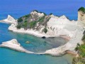 Soczysta zieleń, szum morza, niezwykły klimat - w miejscowości Agios Georgios na greckiej wyspie Korfu można spędzić wakacje marzeń. To raj dla tych, którzy kochają piaszczyste plaże, morską bryzę i piękny krajobraz, cieszący oko w każdym zakamarku miejscowości. To doskonałe miejsce dla rodzin z dziećmi - cisza, gwarantowana dobra pogoda, bezpieczne i piękne plaże - wszystko czego potrzeba, żeby i dzieci i rodzice mogli uznać swój urlop za udany.

Położenie

      Agios Georgios to miejscowość położona na północy greckiej wyspy Korfu (Corfu), nad Morzem Jońskim. Leży ona w pobliżu większych miejscowości, takich jak m. in. Paleokastritsa i Agios Stefanos. To również świetne miejsce wypadowe do Kerkiry (Kerkyary) - stolicy Korfu, oddalonej o około 30 km. Wyspa była niegdyś ulubionym miejscem wypoczynku wielkich tego świata, takich jak Napoleon czy cesarz Wilhelm II. Do dziś przyciąga turystów z całego świata, a twórcy jednej z części James Bonda w okolicznej miejscowości Pagi - kręcili tu najważniejsze sceny filmu 